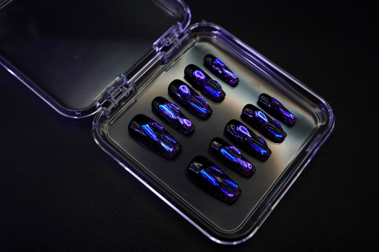 Et komplett Venom Drip negle sett for en 'dark siren'-look. Viser de skarpe, ballerina-formede neglene med lilla og blå skimrende detaljer.