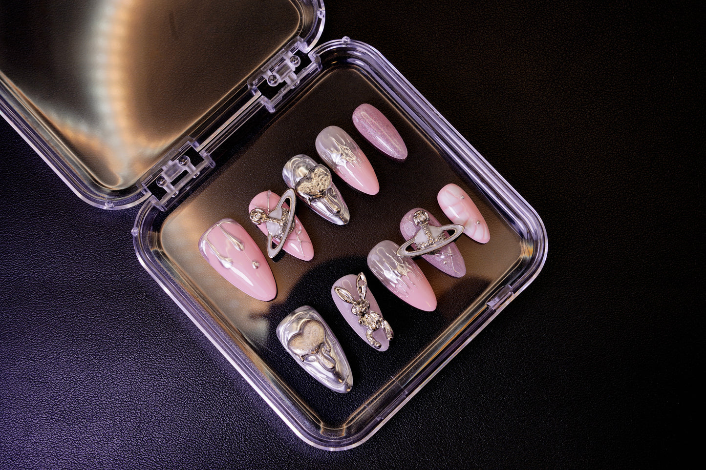 Et komplett Astro Bunny negle sett med et edgy og kosmisk design. Viser en blanding av rosa negler og sølvfargede metall-detaljer.