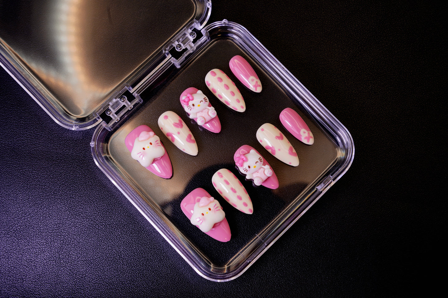 Et komplett Kawaii Crisis negle sett for en 'babycore'-look. Viser de lekne, rosa og kremgule neglene med prikker og 3D-figurer.