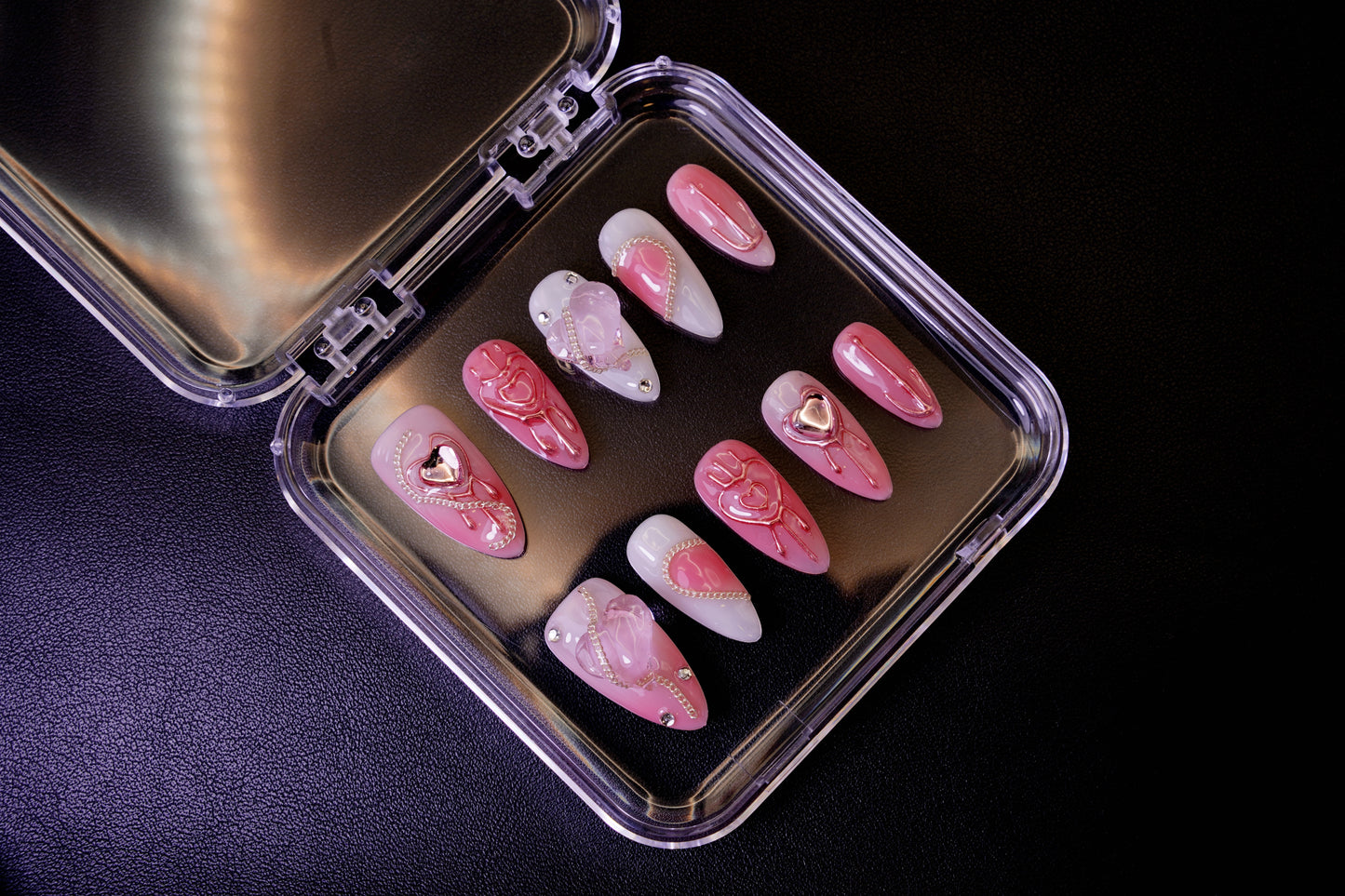 Et komplett Pretty in Pain negle sett for en 'soft savage'-look. Viser de mandelformede neglene med en blanding av myke rosa toner og harde krom-detaljer.