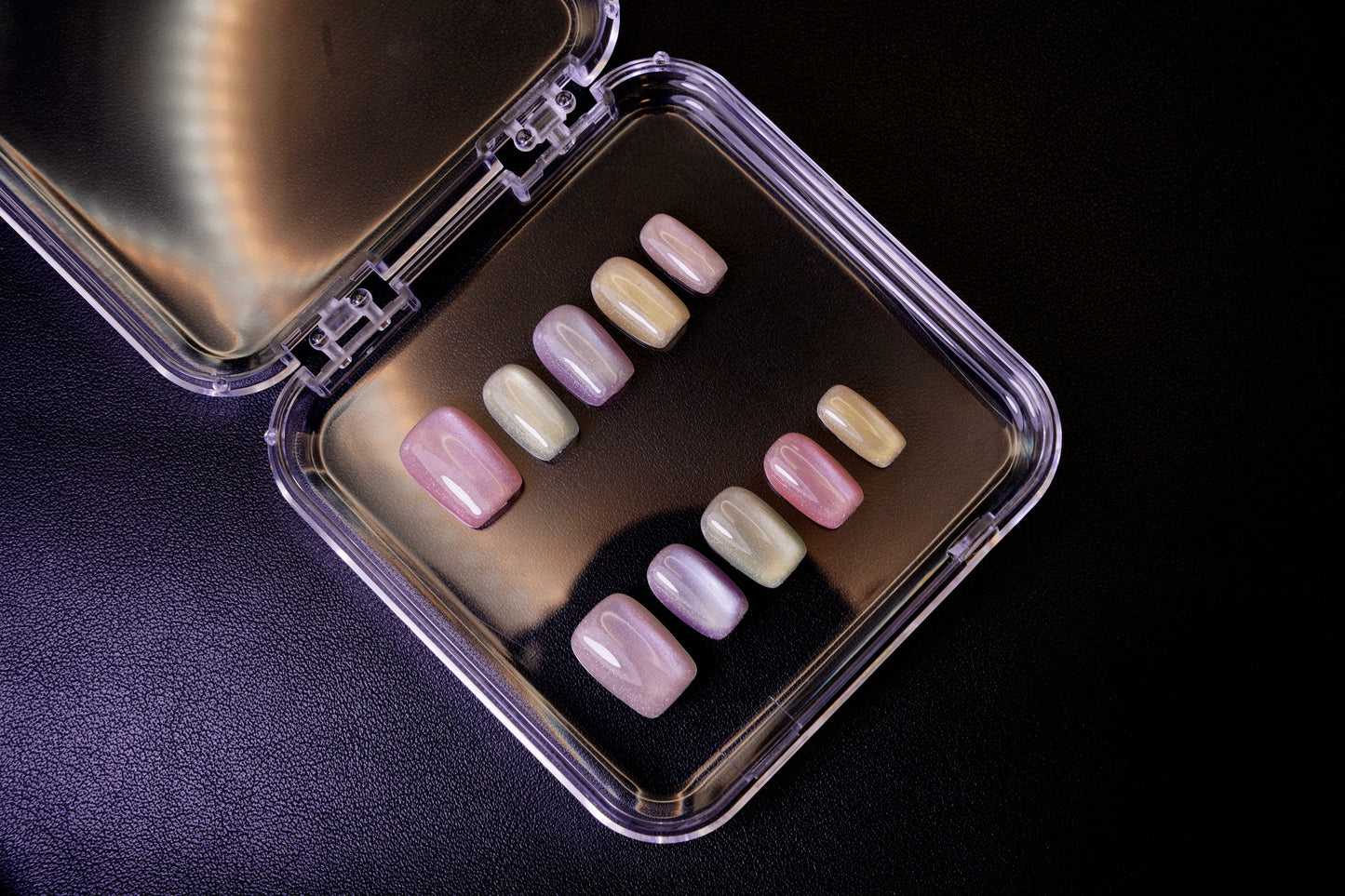 Et komplett Cotton Candy negle sett vist i sitt åpne etui. Viser den myke regnbue-gradienten med en pastellfarget, magnetisk glans.