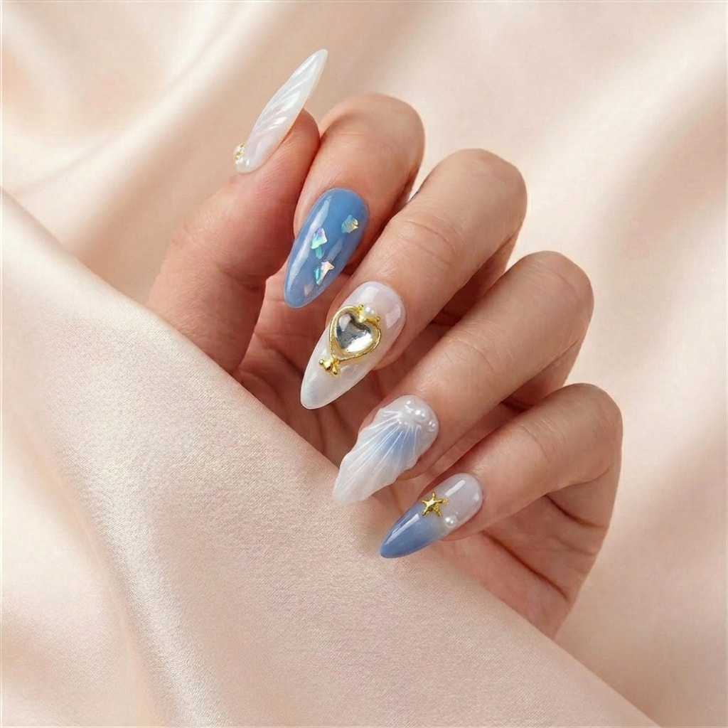 Hånd på silkestoff med See Me Glow press on negler — håndlaget, gjenbrukbare lange almond-negler med iridescent blå accent, 3D sjell-relieff og 3D gull stjerne-charm.