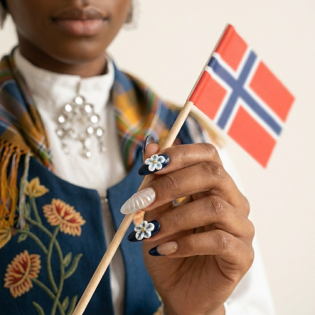 Styled shot med mørkere bunad og sølje-brosje — Hardanger Heiress løsnegler i almond-form med marineblå ombré, 3D blå-hvite blomster og perlemor-aksent.