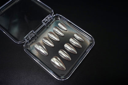 Et komplett Silent Champagne negle sett vist fra siden. De mandelformede løsneglene har en subtil Chrome hvit-farge med en metallisk sateng-glans.