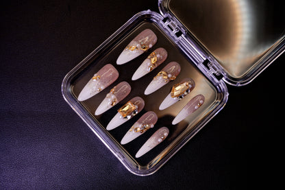 Vinklet bilde av Gold Digger's Gala løsnegler. Viser de overdådige neglene med gullskimmer, store krystaller og perle-detaljer.