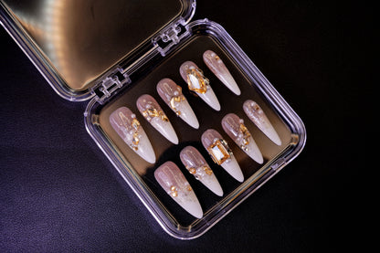 Et komplett Gold Digger's Gala negle sett for en luksuriøs look. Viser de lange stiletto-neglene med en champagne-ombré og gull-detaljer.