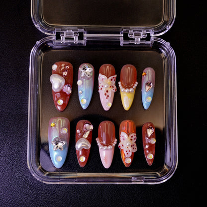 Ovenfra-bilde av det tropiske Starstruck in Waikiki press on negler-settet i etui. Viser de fargerike stiletto-neglene med 3D-blomster, perler og hjerte-charms.