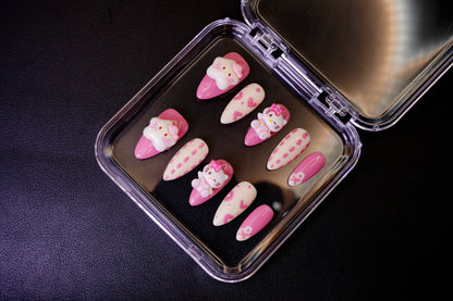 Vinklet bilde av Kawaii Crisis løsnegler. De pastellfargede neglene er dekorert med store, kawaii 3D-charms som Hello Kitty.