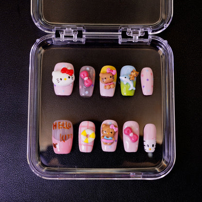 Ovenfra-bilde av Kitty Island press on negler i etui. Viser de mange 3D-figurene, inkludert Hello Kitty, en delfin, og en livbøye for en tropisk følelse.