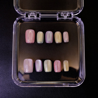 Ovenfra-bilde av Cotton Candy press on negler i etui. De firkantede neglene viser en myk, pastellfarget cat-eye-effekt.