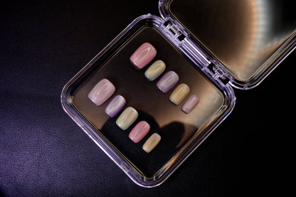 Vinklet bilde av Cotton Candy løsnegler. Viser den skinnende cat-eye-effekten på de pastellfargede, firkantede neglene.