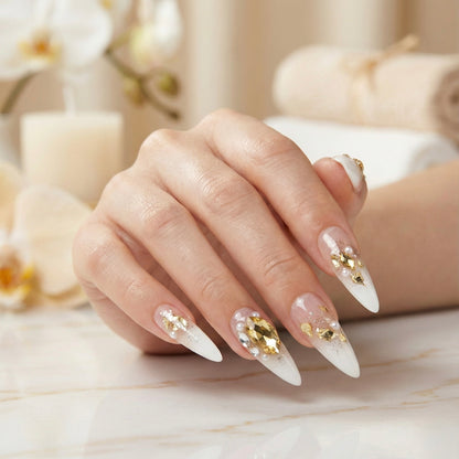 Hand with Gold Diggers Gala press on nails on a blurred background.