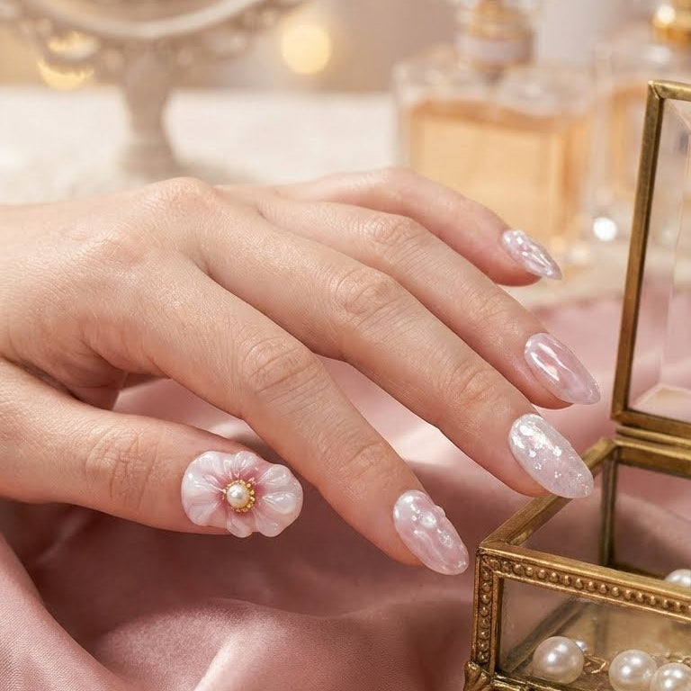 Hand with pink floral nail art showcasing the press on nails in details
