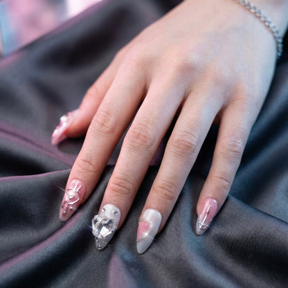 Close-up of a hand with Pretty in pain press on nails on a dark fabric background