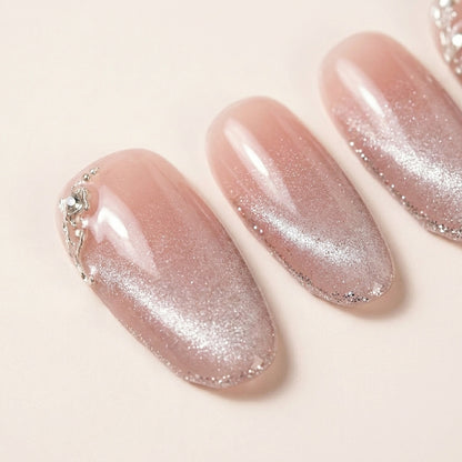 Makro-nærbilde av Angel Glaze løsnegler — falske negler med lim, med detaljer av nude-rosa base, sølvglitter ombré-tipp og små 3D sølv-blad detaljer.