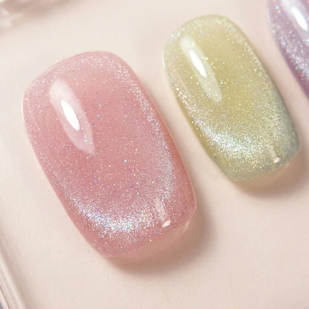 Makro-nærbilde av Cotton Candy løsnegler — falske negler med lim, med pastell cat-eye shimmer og iridescent glossy finish i mintgrønn, rosa og lilla.