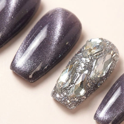 Makro-nærbilde av Frostbite løsnegler — falske negler med lim, med detaljer av 3D krystall-shards, iridescent silver glitter og lavendel cat-eye finish.