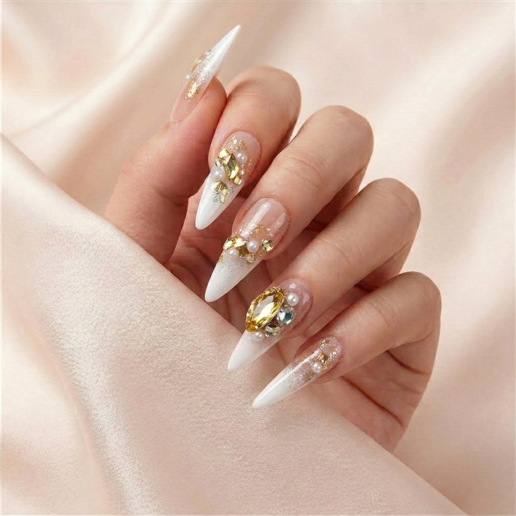Hånd på lyserosa silkestoff med Gold Digger's Gala press on negler — håndlaget, gjenbrukbare stiletto-negler med stor gull gem-accent, perler og champagne ombré.