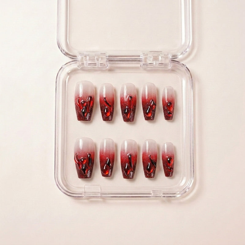 Hotter Than Revenge press on nails i etui — håndlaget sett med coffin-formede negler, milky white base, dyp blodrød ombré-tipp og glossy 3D drip-detaljer.