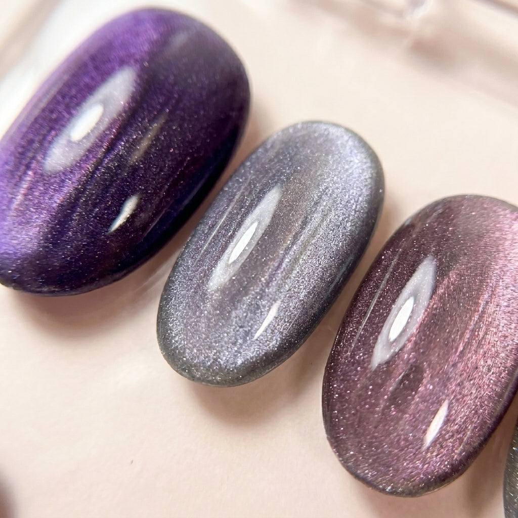Makro-nærbilde av Lavender Haze løsnegler — multichrome cat-eye som skifter mellom lilla og sølv.