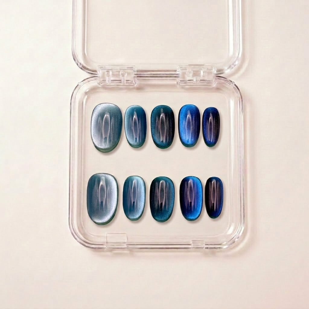 Ocean Eyes press on negler i etui — håndlaget sett med korte oval-negler i blå cat-eye fra sølvblå til marineblå.