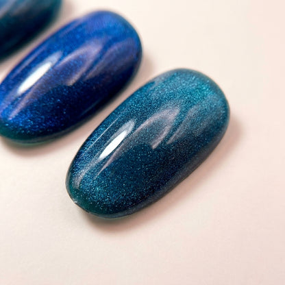 Makro-nærbilde av Ocean Eyes løsnegler — magnetisk cat-eye-effekt i sølvblå og dyp teal.