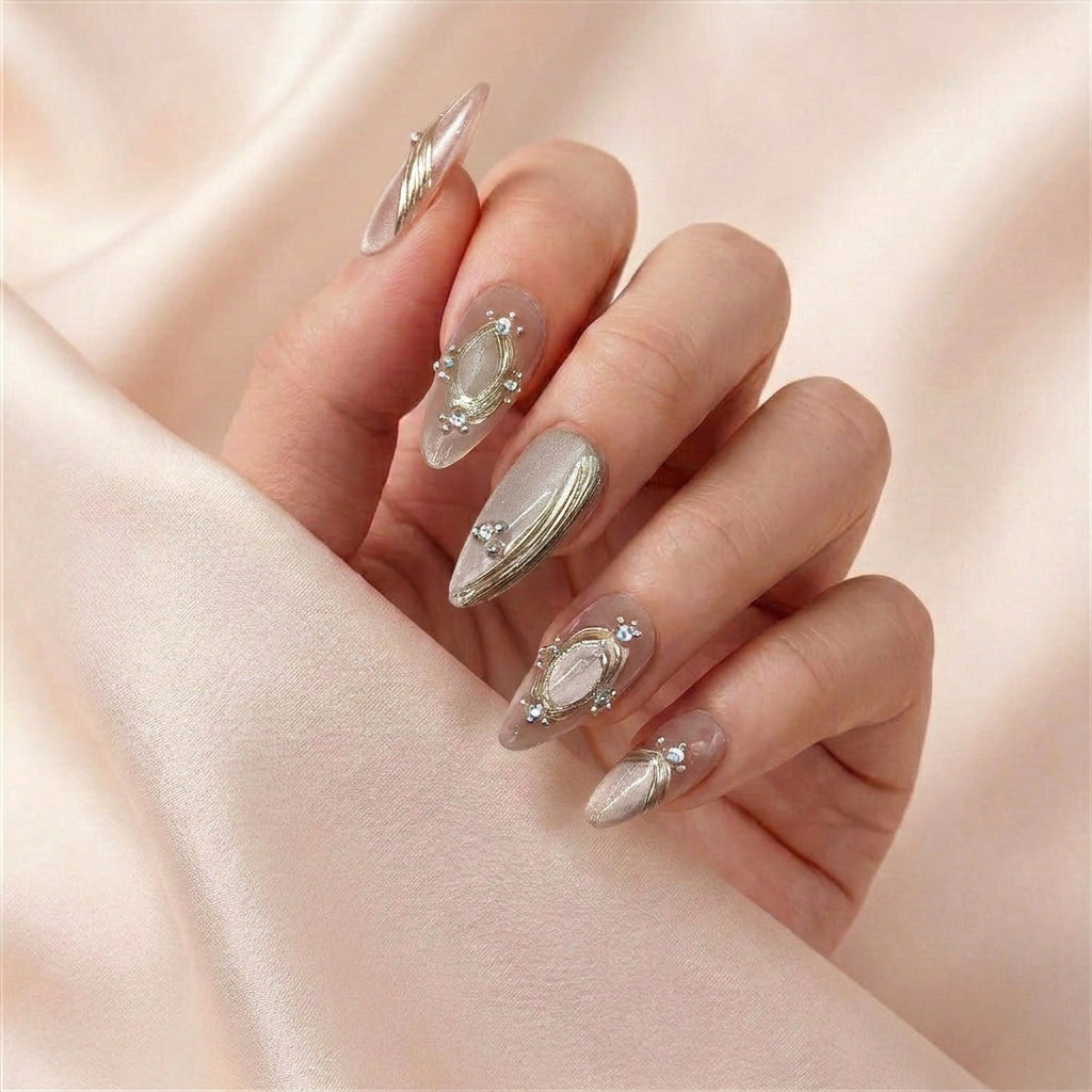 Hånd med Pretty Privilege press on negler — gjenbrukbare almond-negler i rosegull-shimmer med gulltråd-detaljer.