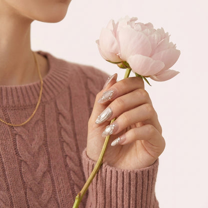 Styled Pretty Privilege negler — rosegull almond-negler med gulldetaljer mot nøytralt stoff.