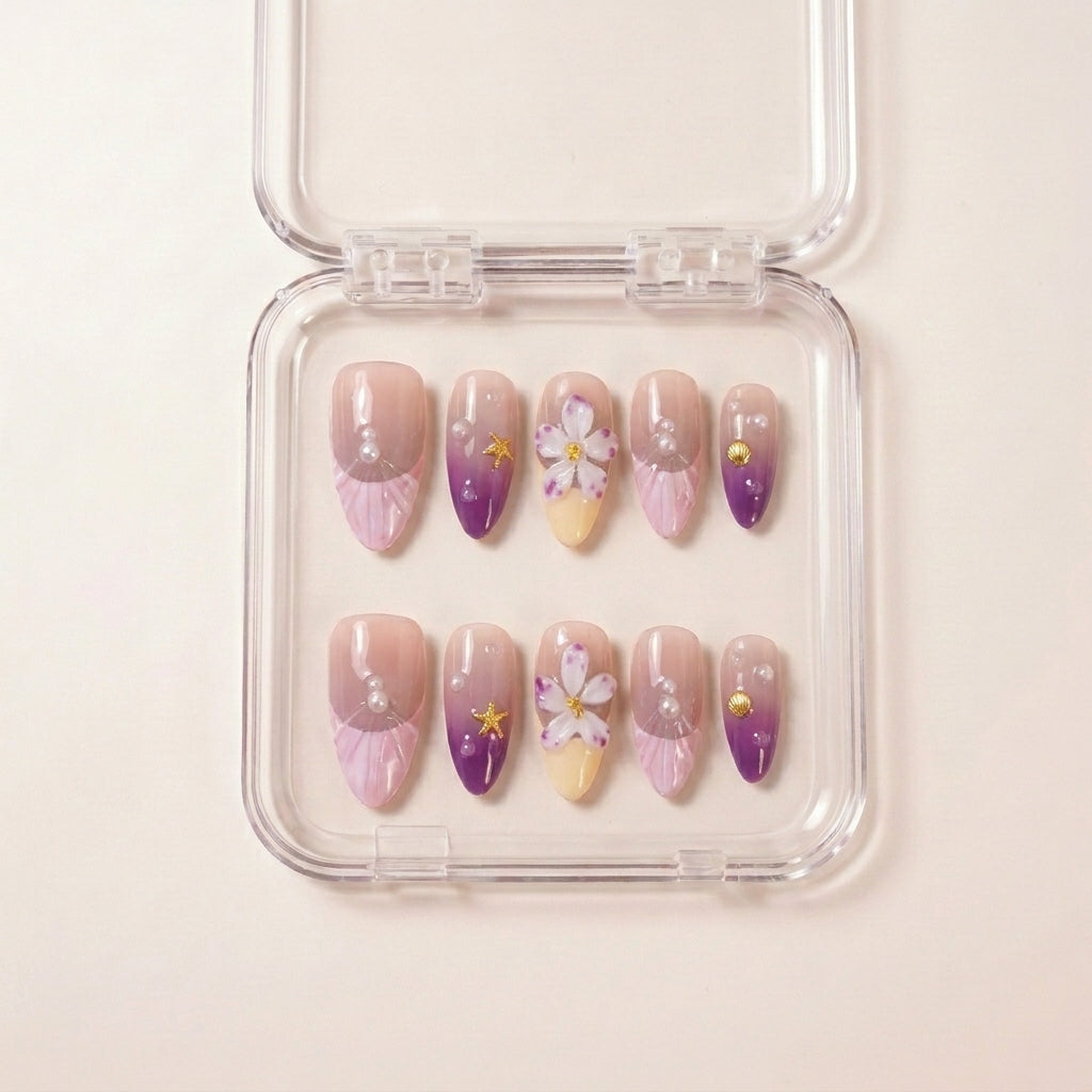 Siren's Blush press on nails i etui — håndlaget almond-negler med lilla ombré, seashell rosa, 3D hvite blomster, perler, sjell-charms og gullfargede sjøstjerner.