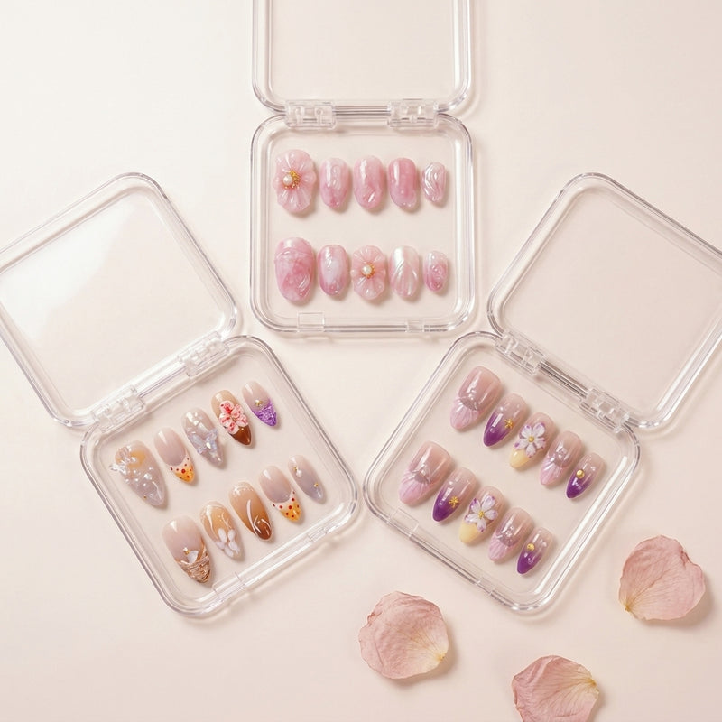 The Cottagecore Edit styled shot — tre transparente esker med Siren's Blush, Coastal Bloom og Flower Therapy press on negler, omringet av rosa rosenblader.