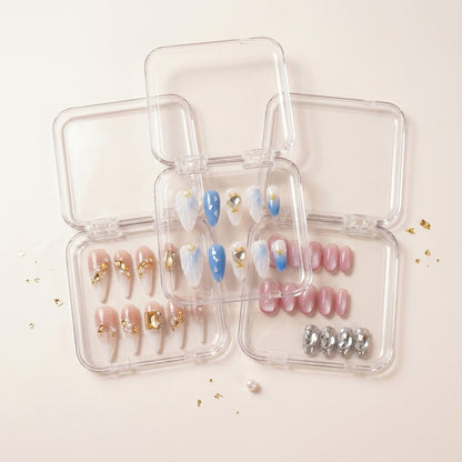 The Glam Edit styled shot — tre transparente esker med See Me Glow havmotiv-negler, Gold Digger's Gala krystall-stiletto og Stardust rosa chrome, strødd med gullflak.