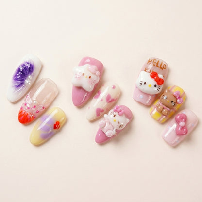 Makro-nærbilde av The Kawaii Edit — håndmalte almond-negler med Hello Kitty-charms, rosa hjerter, bamser og 3D daisy-detaljer fra Kitty Island, Kawaii Crisis og Tutti Cutie.