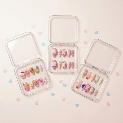 The Kawaii Edit styled shot — tre transparente esker med Kitty Island, Kawaii Crisis og Tutti Cutie press on negler omringet av rosa og blå hjerte-konfetti.