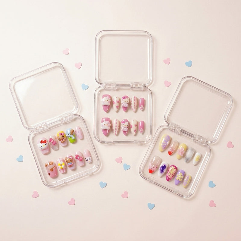 The Kawaii Edit styled shot — tre transparente esker med Kitty Island, Kawaii Crisis og Tutti Cutie press on negler omringet av rosa og blå hjerte-konfetti.