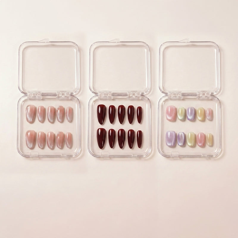 The Minimalist Edit styled shot — tre transparente esker med Angel Glaze nude glitter-negler, Cherry on Top mørk kirsebærrød stiletto og Cotton Candy pastell chrome.